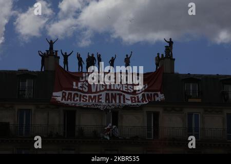 The tenants of the building of the penultimate floor tears the banner of the members of the extreme right group Generation Identitaire (GI) where it is said `` victims of anti-white racism '' during a demonstration `` Black Lives Matter '' against racism and police brutality, on the Place de la République in Paris on June 13, 2020. The banner which unfolded on the balcony below, was torn and cut by the residents of the apartment . (Photo by Mehdi Taamallah/NurPhoto) Stock Photo
